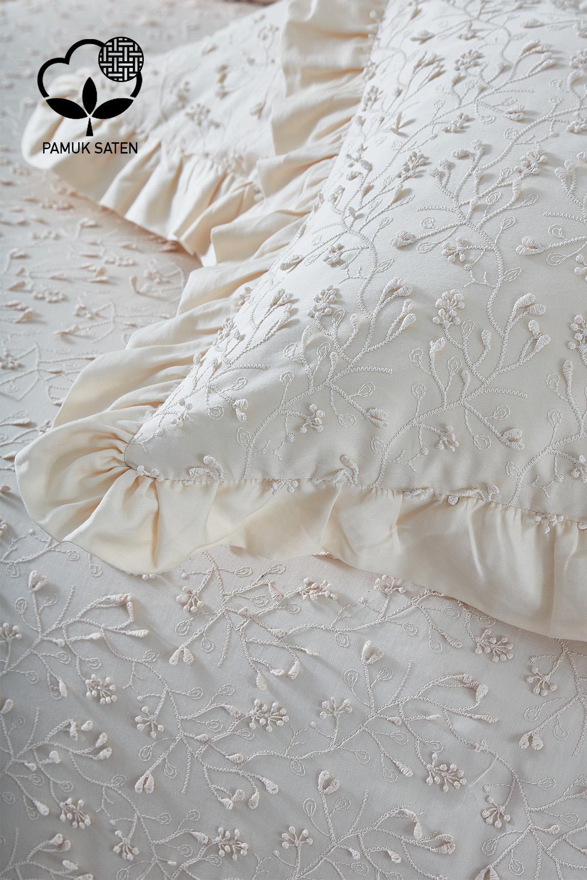 Bestickte Bettwäsche aus cremefarbener Baumwollsatin für Doppelbetten, mit Blumenmuster und Rüschenkissen.