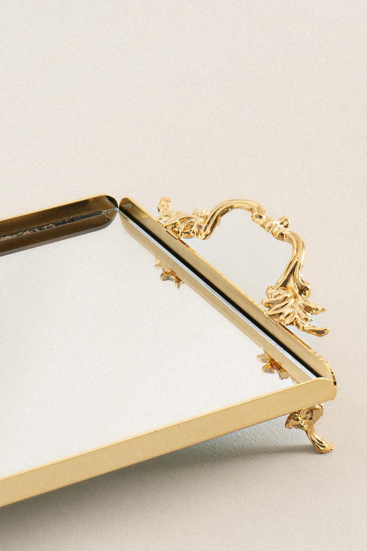 Kleine, elegante Servierplatte mit goldenen Griffen, dekorativen Füßen und rechteckiger Spiegelfläche.