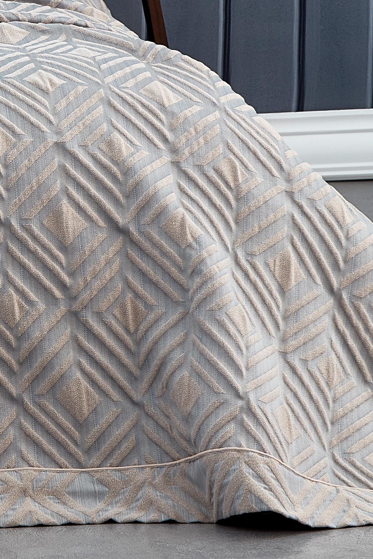 Detailansicht einer doppelseitigen Jacquard-Tagesdecke mit geometrischem Muster in Grau und Beige