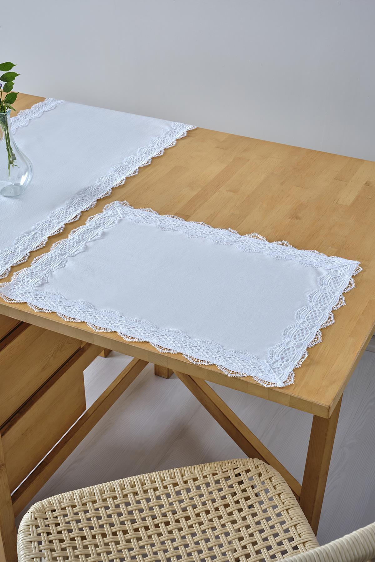 Weiße Platzmatte mit Spitzenrand, Tischdeckendekoration auf einem Holztisch mit Stuhl