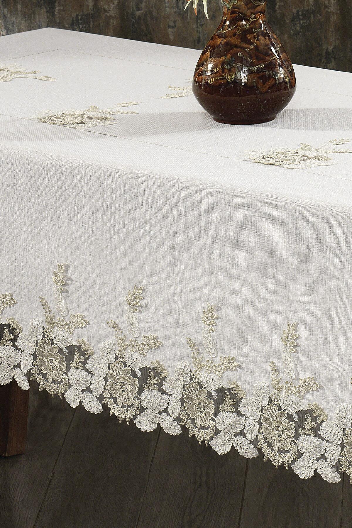 Spitzen-Tischdecke in Creme, fleckabweisend; neben einem eleganten Gedeck und einer Keramikvase.