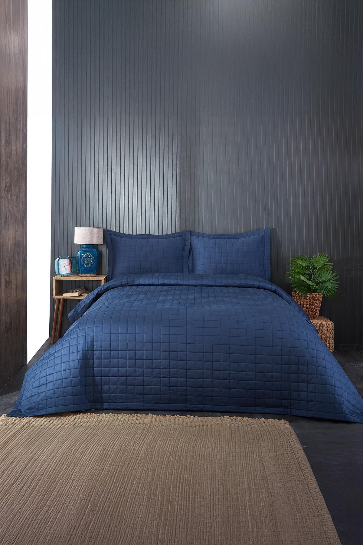 Dunkelblaue gesteppte Doppelbettdecke mit Kissenbezügen in einem modernen Schlafzimmer
