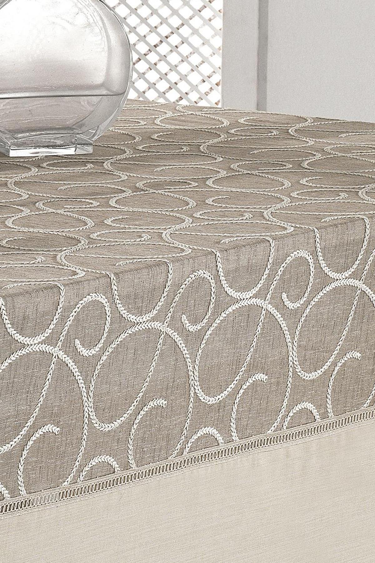 Beige gemusterte, fleckabweisende und pflegeleichte Tischdecke, schlichte Vase auf einem rechteckigen Tisch