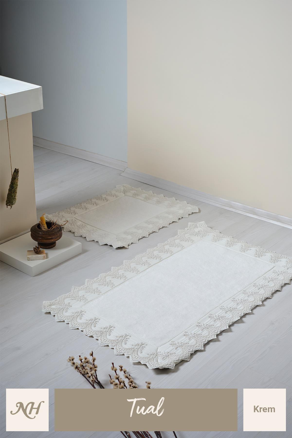 Cremefarbenes, spitzenverziertes 2-teiliges Badematten-Set auf einem modernen und eleganten Badezimmerboden