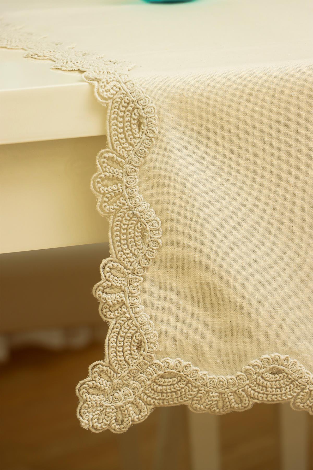 Cremefarbene Tischdecke mit elegantem Spitzenrand, moderne Tischdekoration.
