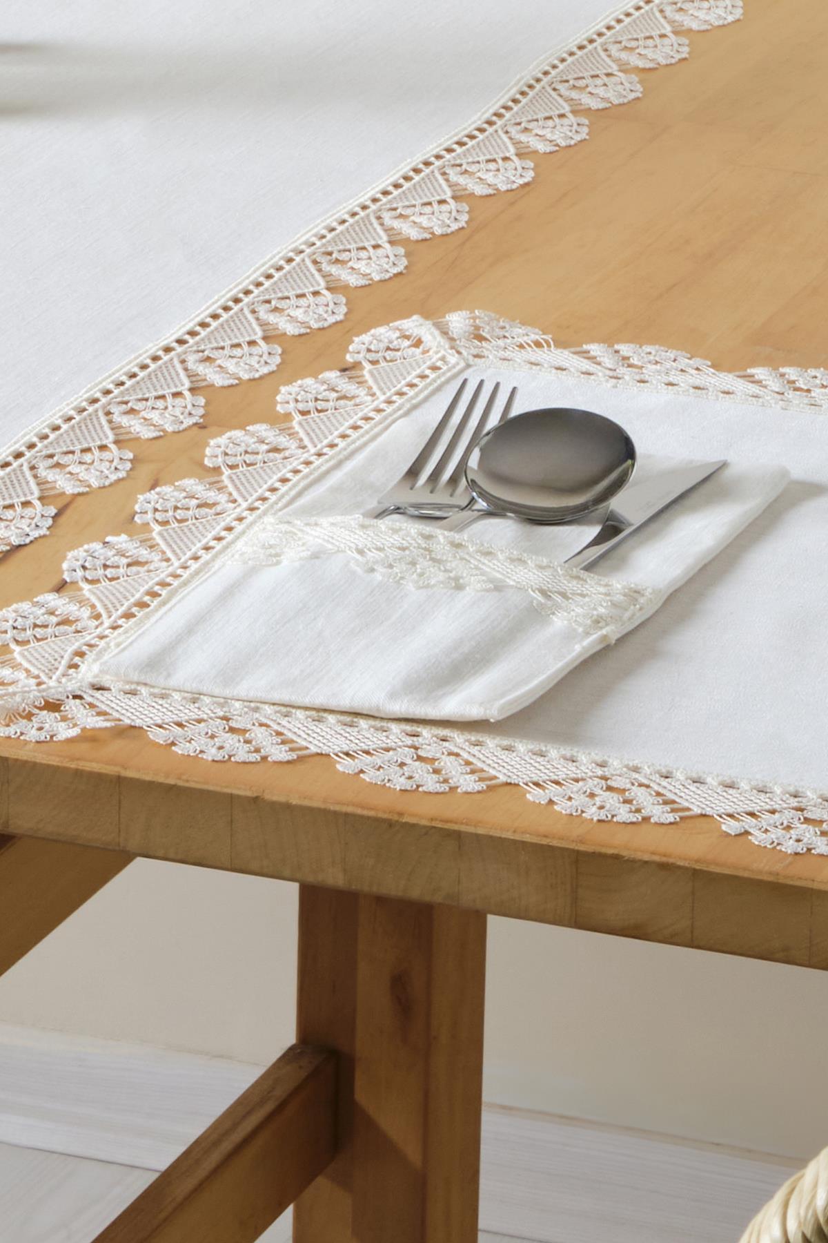 Spitzentischdecke und Set aus weißen Servietten mit Besteck auf einem Holztisch